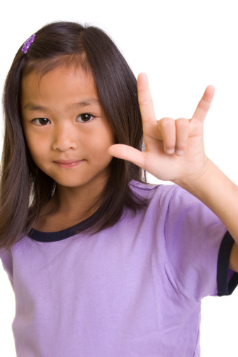 Little girl using hand gesture for I love you in sign language