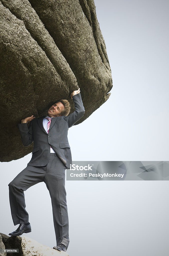 Starke Geschäftsmann hat Schwierigkeiten, um eine Big Boulder - Lizenzfrei Fels Stock-Foto