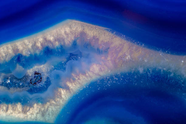 istock Vibrant deep blue and semi-transparent agate geode slice crystal, banded chalcedony stone isolated on a white background surface with lots of detail. Abstract blue crystal wallpaper 1739144145