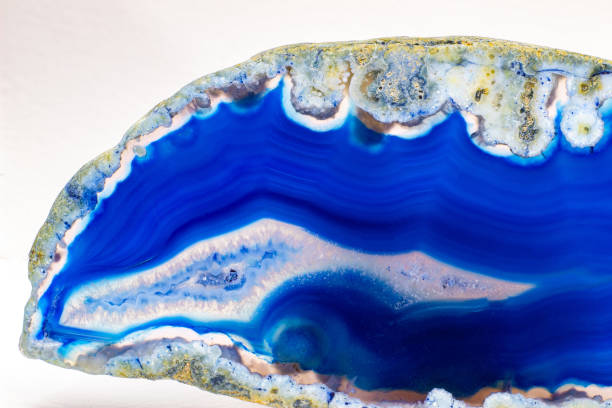 istock Vibrant deep blue and semi-transparent agate geode slice crystal, banded chalcedony stone isolated on a white background surface with lots of detail. Abstract blue crystal wallpaper 1739144167