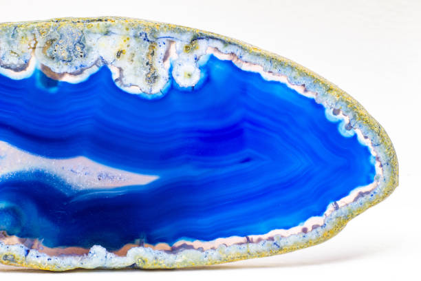 istock Vibrant deep blue and semi-transparent agate geode slice crystal, banded chalcedony stone isolated on a white background surface with lots of detail. Abstract blue crystal wallpaper 1739144181