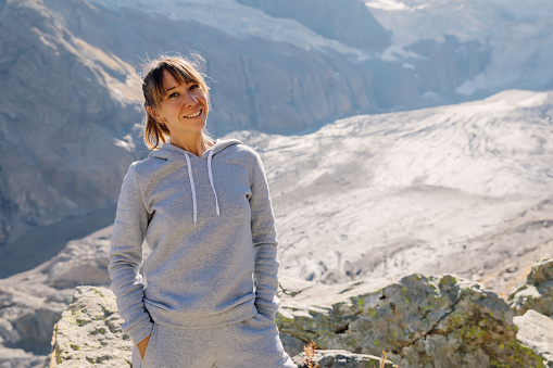 Portrait of beauty smiling woman in the mountains. Mountains with glacier and girl tourist