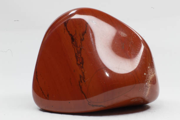 istock Macro brick red tumbled shiny jasper chalcedony crystal, shiny stone, isolated on a white surface background 1739144702