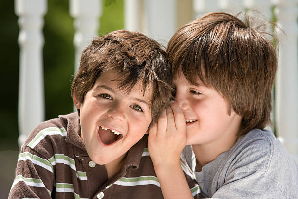 istock boy whispering to his brother 173914601