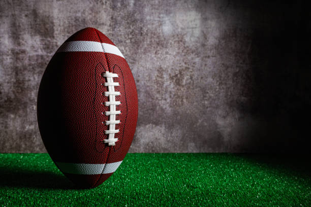 istock Standing american football ball over grass 1739147557