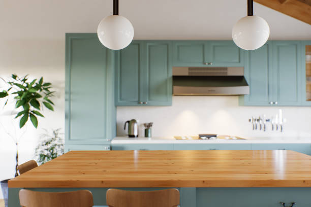 istock Green kitchen with wood countertops and accent island for product display. Empty kitchen countertop with blurred kitchen background with appliances and utensils. 3D rendering. 1739150412