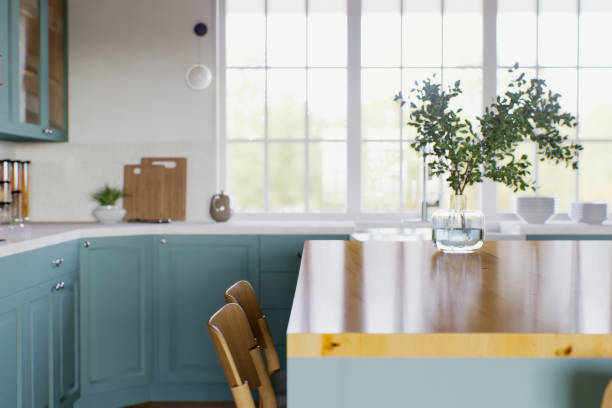 istock Green kitchen with wood countertops and accent island for product display. Empty kitchen countertop with blurred kitchen background with appliances and utensils. 3D rendering. 1739150424
