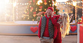 Happy caucasian couple in love on romantic date walking city streets Christmas fair time over light bokeh. Pastime together. Romantic, love family and greeting concept New Year winter. Copy space