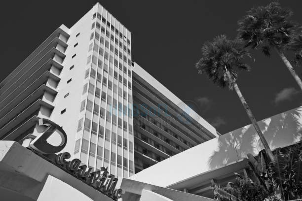 Accordion shutters are covering second story windows in preparation for and impending storm in black and white.
