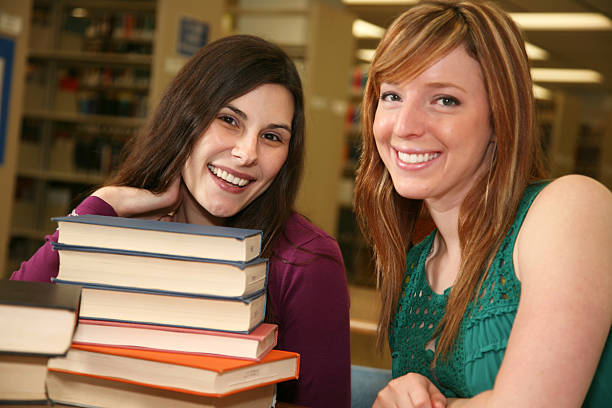 istock Two Female College Students With Stacks of Library Books 173916887
