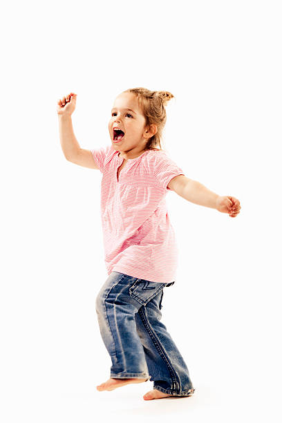 Sweet little girl having fun, singing and dancing. On white background.