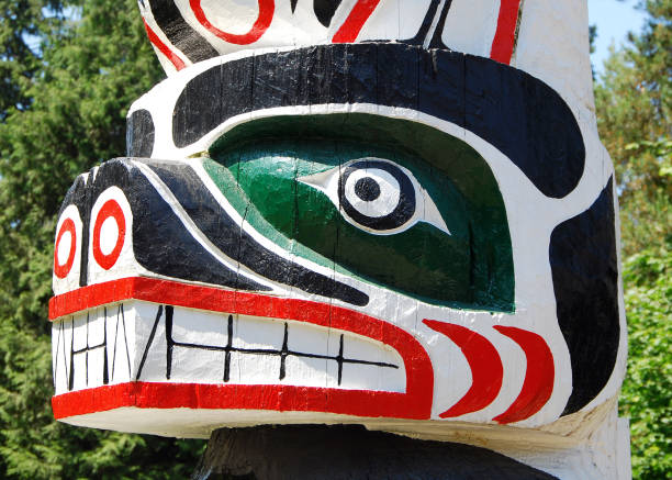 Totem Pole Detail "Close up of a totem pole in Vancouver, BC. Totem poles are monumental sculptures carved from trees, usually cedar, by various Indigenous people along the Pacific northwest coast of North America. Vancouver lightbox" pacific northwest totem poles stock pictures, royalty-free photos & images