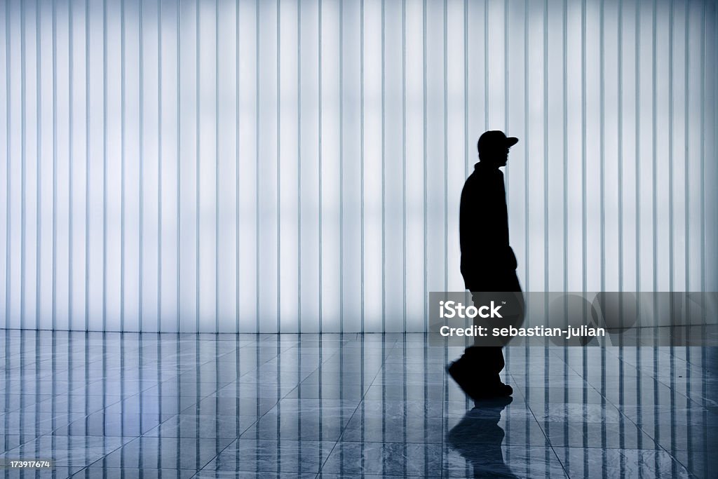 gangster in motion XXXL - silhouette of suspect person with baseball cap against illuminated wall - camera canon 5D mark II - unsharped RAW - adobe colorspace Rap Stock Photo