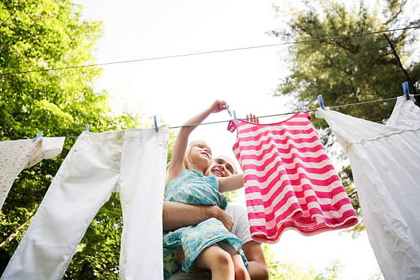 Child and Man Hanging Laundry in the Backyard stock photo