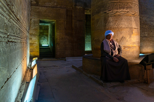 Kom Ombo, Egypt - April 17, 2000.  Temple of Haruris and  Sobek.  An Egyptian temple guide pointing to an image on the wall of the temple.