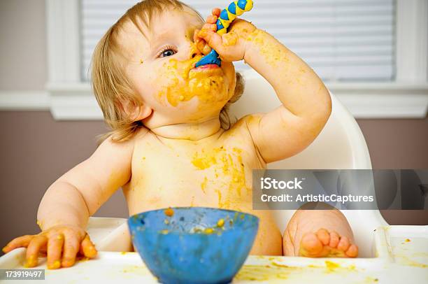 Messy Baby Eating Food In High Chair Stock Photo - Download Image Now - Messy, Baby - Human Age, Baby Food