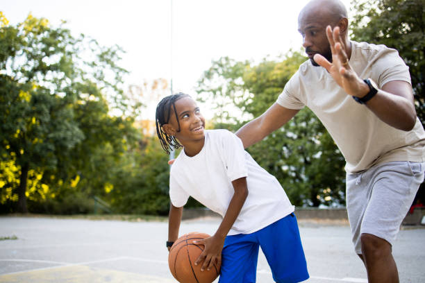 istock Boy having fun dribbling his dad in basketball 1739196117