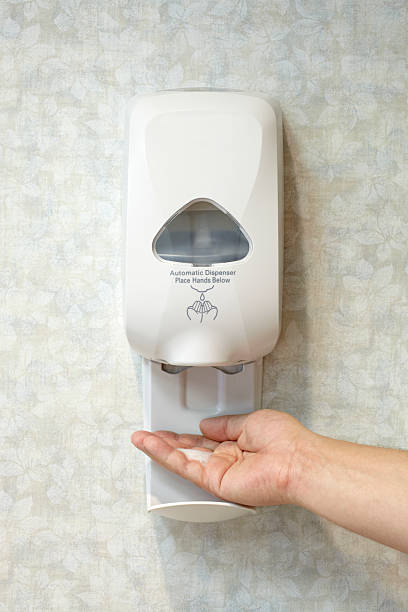 Male Caucasian Hand with Antibacterial Soap Sanitizer Dispenser stock photo