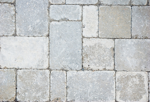 Closeup image of grey cobblestones, arranged in attractive pattern.