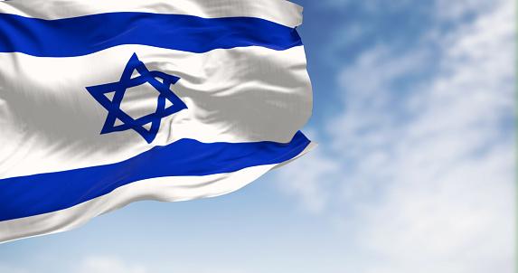 State of Israel national flag waving in the wind on a clear day. Blue Star of David in the center, flanked by two horizontal blue stripes on a white field. 3d illustration render. Selective focus