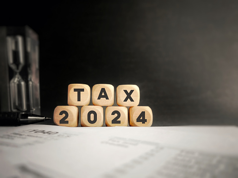 Tax 2024 on wooden cube background. Tax season concept.