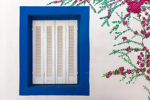 Blue window with mural in Greece