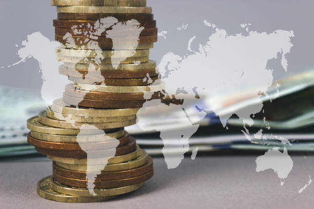 istock Coins stack and stack of one hundred dollar bills with Digital Earth planet Global world map symbol on grey background. 1739216132