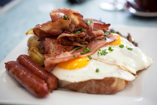 A delicious plate of traditional bacon, fried eggs, sausages and potato rosti on thick sourdough toast. More Food and Drink.