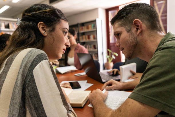 istock Young students studying together in the library at university 1739221471