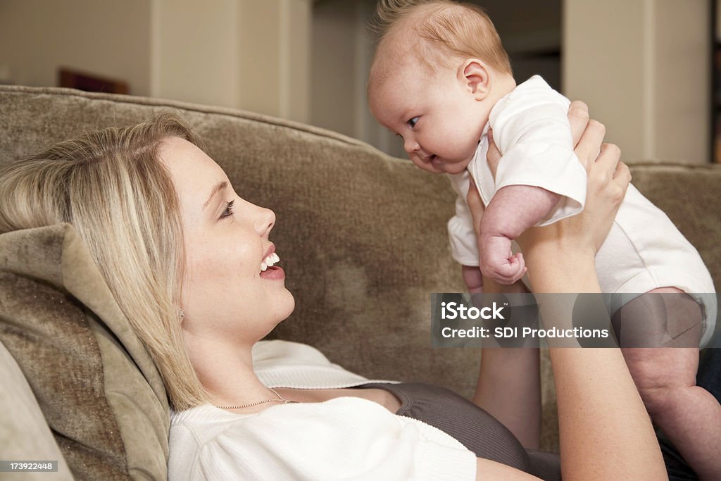 赤ちゃんの女の子の彼女の母親を味わうには、ソファー - 2人のロイヤリティフリーストックフォト