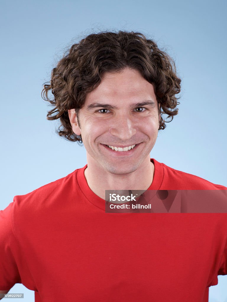 Ritratto di un sorridente giovane maschio con camicia rossa vuota - Foto stock royalty-free di Abbigliamento casual