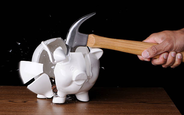 Hammer Smashing Piggybank Full of Coins stock photo