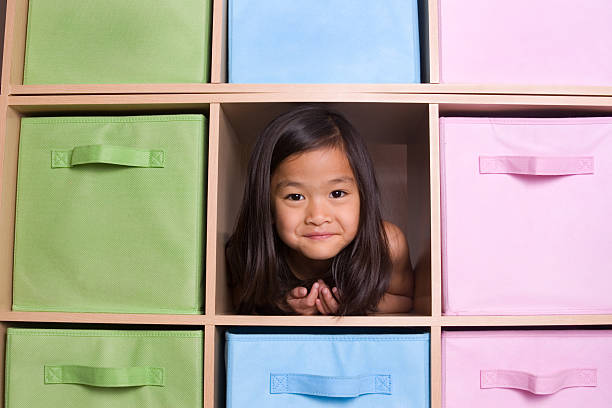 istock Girl peeking through cubed shelving unit 173923454