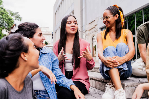 istock Young friends talking sitting on ground outdoors 1739235517