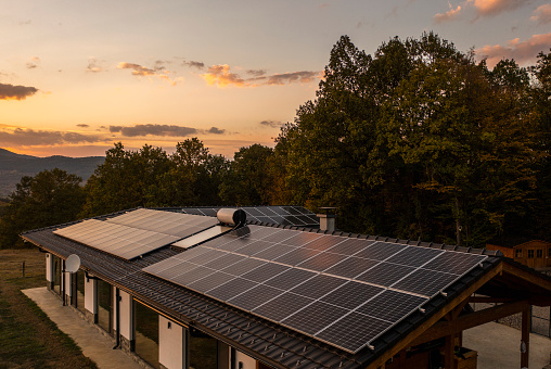 Aerial view of solar powered house in nature shot at sunset.