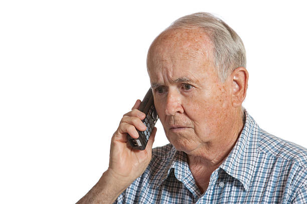 Elderly man on a cordless phone receiving bad news Elderly man on phone getting bad news comb over stock pictures, royalty-free photos & images