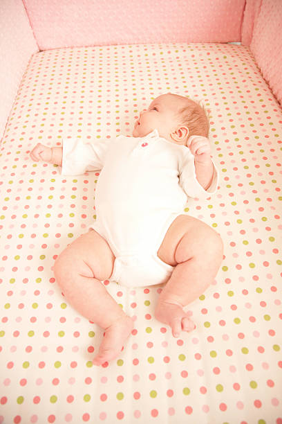 istock Small Baby Lying in Her Crib 173924019