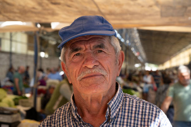 Authentic portrait of beautiful old turkish man selling fresh organic vegetables on market stock photo