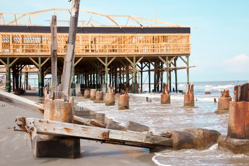 Construction on the beach front.  Eight months after Hurricane Ike lashed out at the Island of Galveston,on September 2008, the city is slowly coming back to life.  In the foreground are what remains of a structure destroyed during the hurricane.  In the background can be seen the new construction of a souvineer shop that will soon reopen along the seawall.