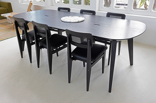 Chairs around black large wooden table
