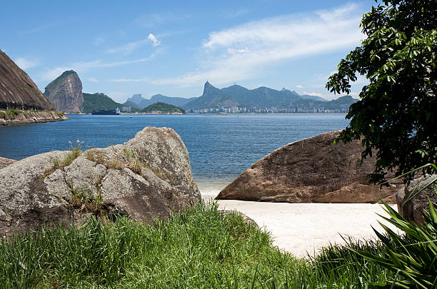 Unique view of Rio de Janeiro and its landmarks as Sugar Loaf and Corcovado mountains from a off the beaten path secluded beach in Niteroi city, in the opposite side of Guanabara Bay.Brazil.