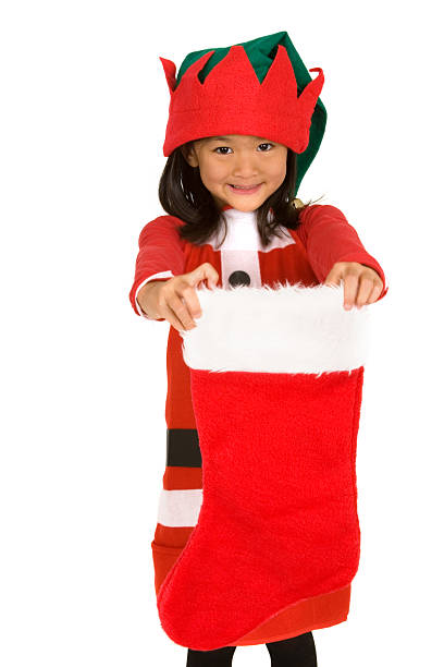 Chinese little girl dressed like elf holding Christmas stocking (shallow dof)