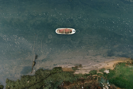 A wooden boat in a marsh area as seen from directly above