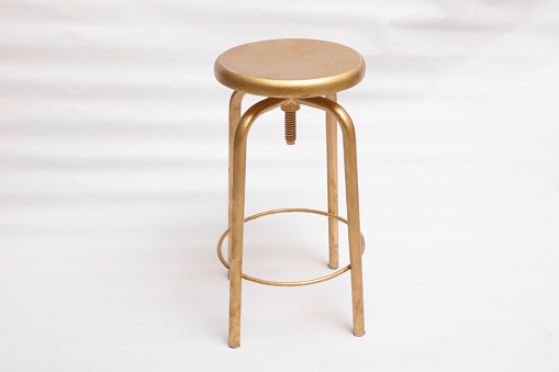 gold colored stool on white background