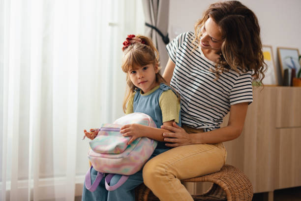 istock A Cute Child Looking At Camera While Her Mother Is Doing Her Hair 1739247040