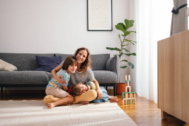 istock A Happy Beautiful Woman Looking At Camera While Enjoying Spending Her Leisure Time At Home With Her Cute Children 1739247073