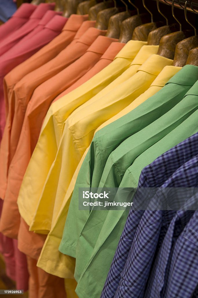 Colorful shirts on a rack ready for spring. "Colorful men's shirts on a rack in green, yellow, orange, red, and blue, mark the change to the spring season in a retail apparel store." Store Stock Photo