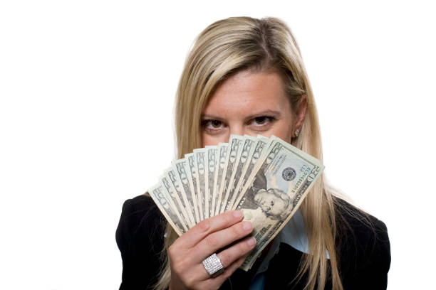 Attrctive women peering over money stock photo