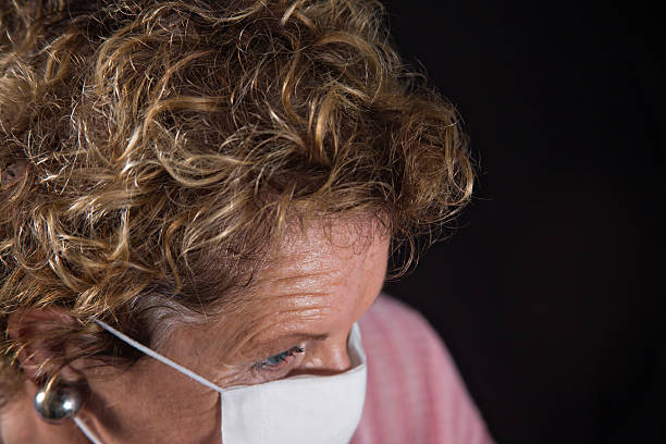 istock caring senior woman in flu face mask 173927841