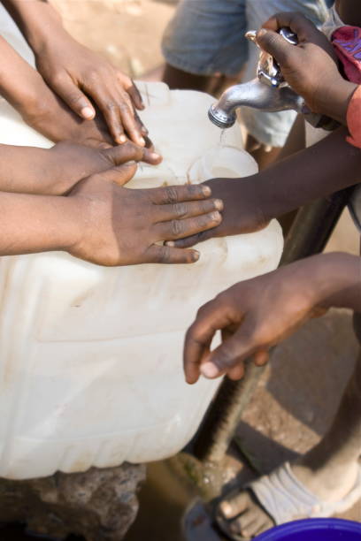 istock African Children's Hands Around a Water Pump 173928304